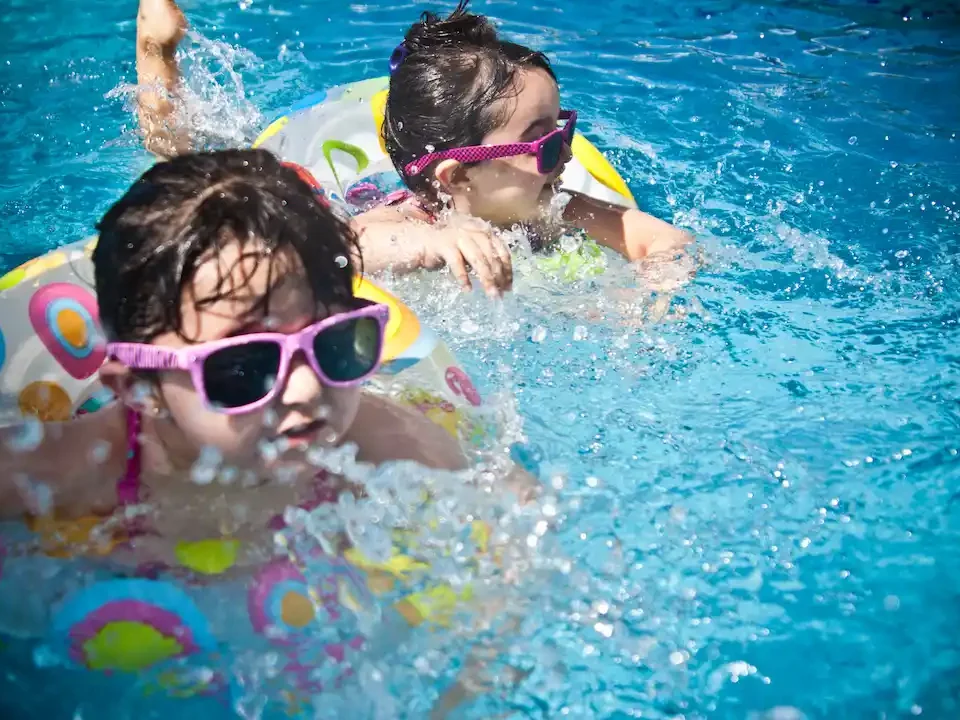 Two girl are swimming in a fiberglass swimming pool in Raleigh, NC.
