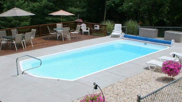 Swimming pool with pool lounge chairs and outdoor dinning set.