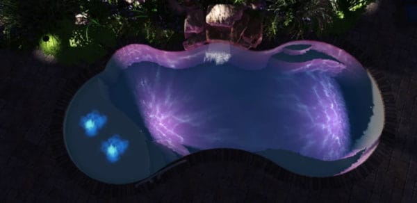 Fiberglass swimming pool at night with purple lights.