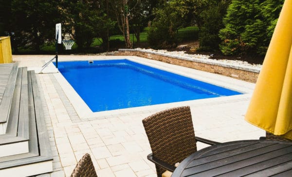 Swimming pool with outdoor dinning set and pool basketball hoop..