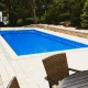 Swimming pool with outdoor dinning set and basketball hoop