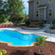backyard inground fiberglass pool with beautiful landscaping