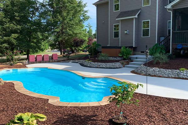 backyard inground fiberglass pool with beautiful landscaping