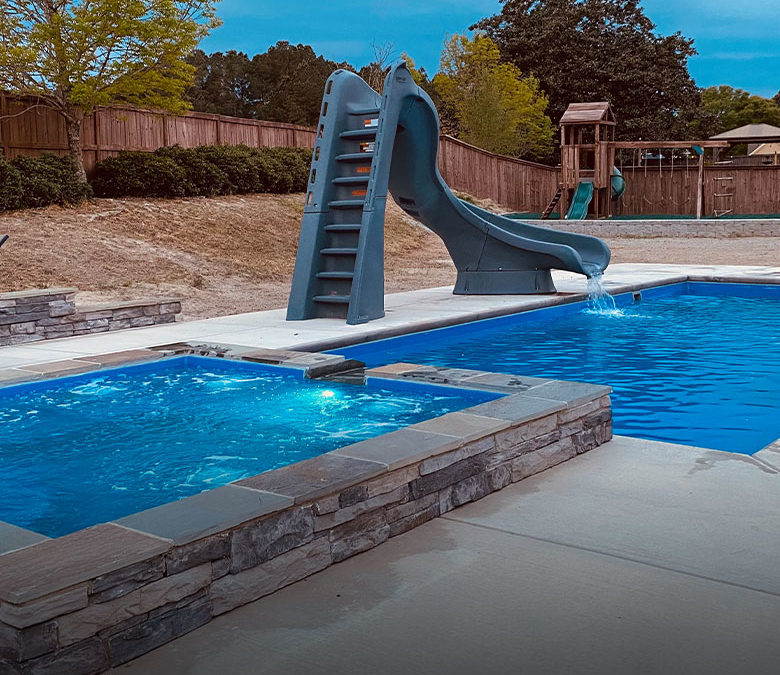 inground fiberglass pool with spillover spa and twist slide