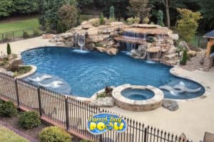 inground fiberglass pool with huge rock formation waterfall and tunnel slide