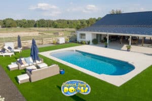 inground fiberglass pool with large covered patio and lush grass