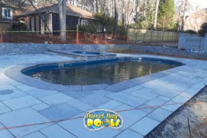 inground fiberglass pool with spillover spa and tile decking