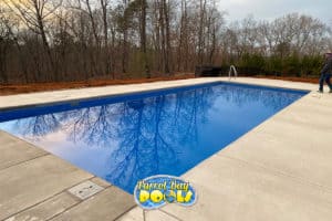 newly installed inground fiberglass pool with concrete decking