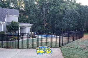 inground fiberglass pool with black fencing