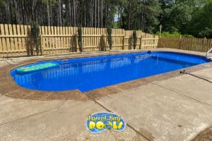 inground fiberglass pool with wood fencing