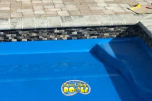 inground fiberglass pool with mosiac tile detail