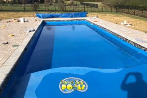 inground fiberglass pool with mosaic tile detail and pool cover