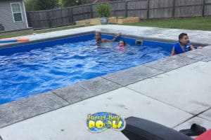 three kids play in their new inground fiberglass pool