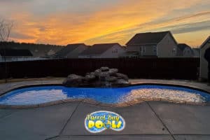 inground fiberglass pool with rock formation water feature