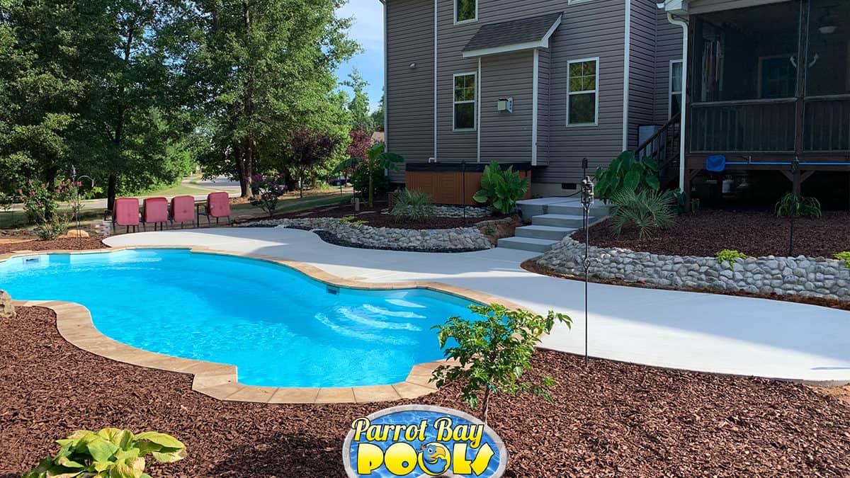 inground fiberglass pool with beautiful landscaping