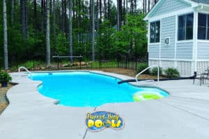 inground fiberglass pool with concrete patio