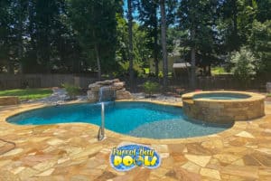 inground fiberglass pool with spillover spa and waterfall rocks