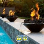 inground fiberglass pool with fire bowls and waterfalls