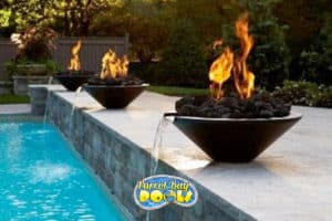 inground fiberglass pool with fire bowls and waterfalls